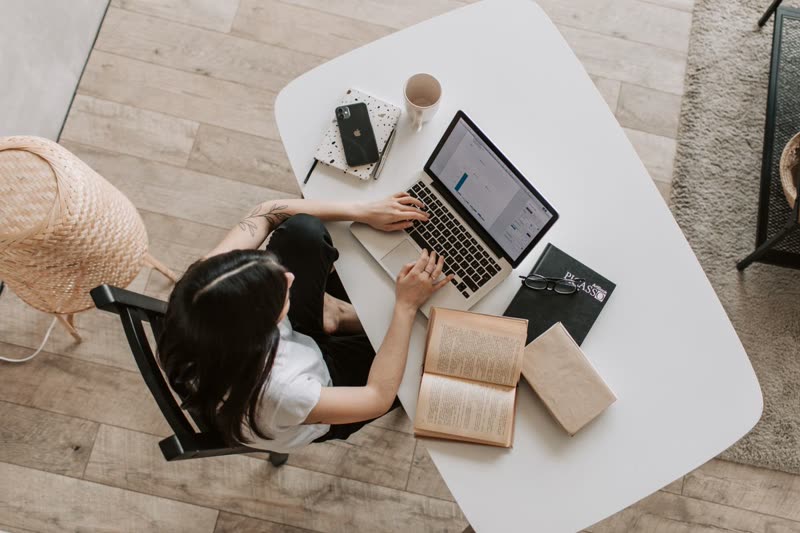 Small business owner working on a laptop at a bright desk